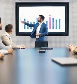 Financial advice presentation man showing graph to table full of people